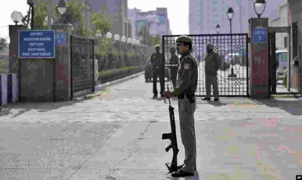 A Delhi policeman stands guard near the gate of a district court where the accused in a gang rape are undergoing trial, in New Delhi, India, January 24, 2013. 