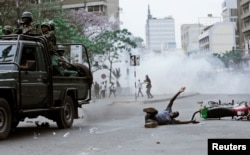 A supporter of Kenyan opposition National Super Alliance (NASA) coalition lies on the ground after he was hit by a police truck during a protest along a street in Nairobi, Kenya, Oct. 11, 2017.