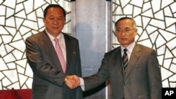 South Korean nuclear envoy Wi Sung-lac (R) shakes hands with his North Korea's counterpart Ri Yong Ho at the private Chang An Club in Beijing, China, September 21, 2011.