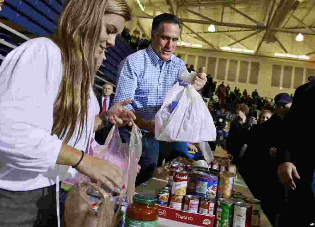 Kandidat presiden dari Partai Republik Mitt Romney membagikan tas berisi makanan kepada organisasi amal di Kettering, Ohio, untuk korban badai super Sandy (30/10).