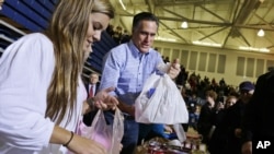 Republican presidential candidate Mitt Romney holds bags of food as he participates in a campaign event collecting supplies from residents local relief organizations for victims of superstorm Sandy in Kettering, Ohio, Tuesday, Oct. 30, 2012.