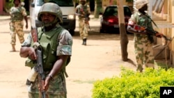 FILE - Nigerian soldiers stand guard at the offices of the state-run Nigerian Television Authority in Maiduguri.