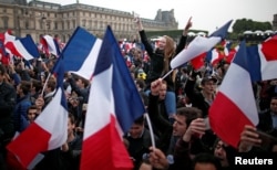 Supporters of Emmanuel Macron celebrate near the Louvre museum after projections were announced in the second round voting in the 2017 French presidential elections, in Paris, France, May 7, 2017.