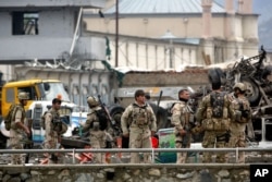 FILE - In this Tuesday, April 19, 2016 file photo, Afghan security forces inspect the site of a Taliban-claimed deadly suicide attack in Kabul, Afghanistan.