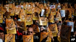 Demonstrators holding banners that read in Catalan: "Freedom for the Political Prisoners," are seen during a protest against the decision of a judge to jail ex-members of the Catalan government, at University square in Barcelona, Spain, Nov. 5, 2017.