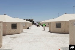 The undated photo released by U.S. Department of Health and Human Services shows detainees walk in a line at the HHS' unaccompanied alien children program facility at Tornillo, Texas.