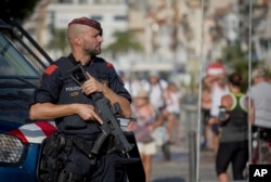 An armed policeman stands on the spot where terrorist were shot by police in Cambrils, Spain, Aug. 18, 2017.