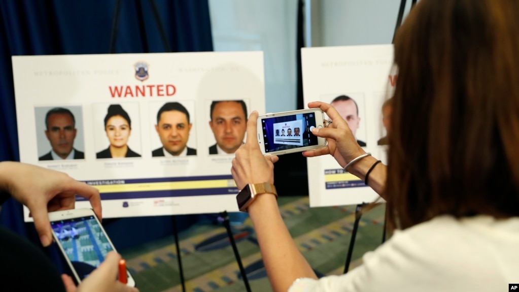 Reporters photograph wanted posters of people facing criminal charges before a news conference in Washington, June 15, 2017, about the May 16, 2017 altercation outside the Turkish Embassy in Washington during the visit of the Turkish president. 