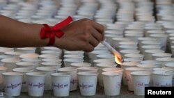 FILE - A campaign supporter lights candles in the Philippines as part of commemorations of International AIDS Candlelight Memorial Day in Quezon city, metro Manila, the Philippines, May 14, 2016. 