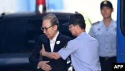 Mantan Presiden Korsel Lee Myung-bak (kiri) dibantu oleh seorang pejabat penjara setibanya di pengadilan Seoul, 6 September 2018. (Foto: dok).