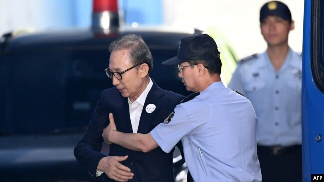 韩国前总统李文博抵达首尔一家法庭参加庭审。（2018年9月6日）