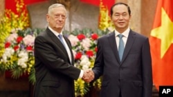 FILE - U.S. Secretary of Defense Jim Mattis, left, shakes hands with Vietnamese President Tran Dai Quang before holding talks in Hanoi, Vietnam, Jan. 25, 2018.