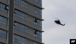 Un helicóptero de la fuerza aérea de Sri Lanka vuela sobre un edificio donde se sospecha se esconden militantes después de un tiroteo en Colombo, Sri Lanka, relacionado con los ataques a iglesias y hoteles el domingo 21 de abril de 2019.
