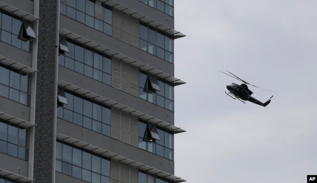 Un helicóptero de la fuerza aérea de Sri Lanka vuela sobre un edificio donde se sospecha se esconden militantes después de un tiroteo en Colombo, Sri Lanka, relacionado con los ataques a iglesias y hoteles el domingo 21 de abril de 2019.