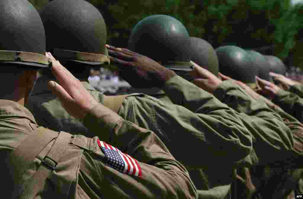 Các diễn viên dựng lại cảnh thời Thế chiến tranh thứ hai, chào quốc kỳ trong khi quốc ca cất lên trong lễ kỷ niệm 70 năm Ngày Chiến thắng ở châu Âu tại Đài tưởng niệm Quốc gia Thế chiến thứ hai ở thủ đô Washington, Mỹ.