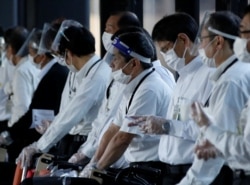 Petugas yang menggunakan pelindung wajah dan masker menunggu penumpang yang membutuhkan kursi roda di pintu kedatangan Bandara Internasional Narita pada hari pertama penutupan perbatasan untuk mencegah penyebaran varian baru omicron di Narita, timur Tokyo, Jepang, 30 November. ( Foto: Reuters)