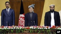 In this photo released by Afghanistan's Presidential Palace, President Ashraf Ghani, center, stands at attention for the national anthem during a joint meeting of the National Assembly in Kabul, Afghanistan, April 25, 2016.