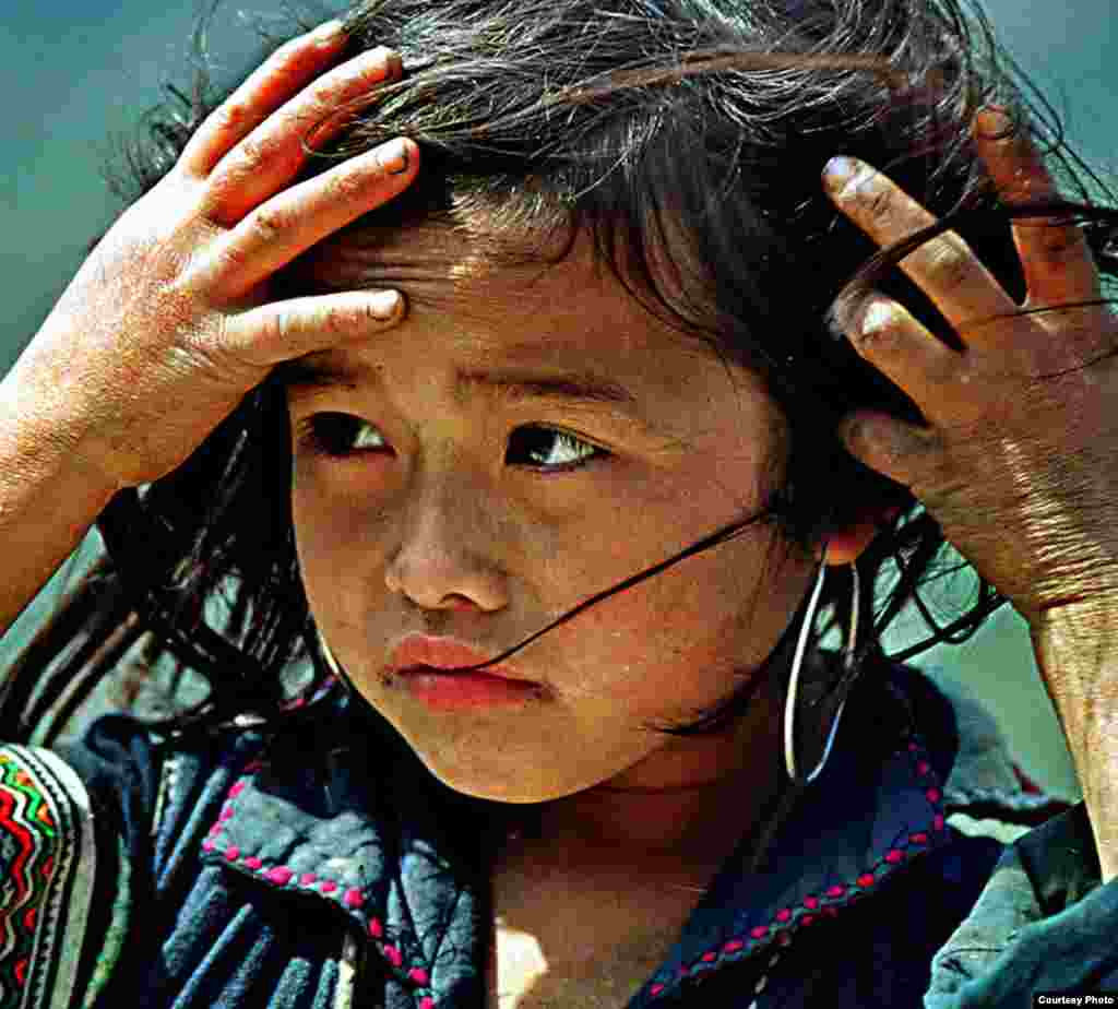 An ethnic Hmong girl tries to keep his hair from getting messed up after a strong wind on a rocky mountain district of Sa Pa, Lao Cai province in northwest Vietnam. (Photo by Đ&igrave;nh H&agrave; /Vietnam/VOA reader)