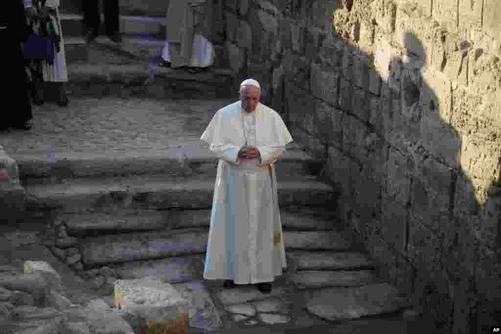 Pope Francis prays as he visits the Bethany beyond the Jordan, which many believe is the traditional site of Jesus' baptism, in South Shuna, Jordan, May 24, 2014.
