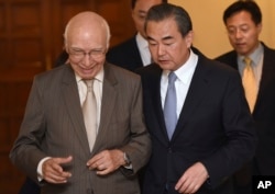 Visiting Chinese Foreign Minister Wang Yi, right, and Pakistan's adviser on foreign affairs Sartaj Aziz, left, leave after a press conference, in Rawalpindi, Pakistan, June 25, 2017.