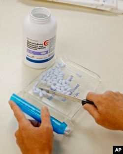 FILE - In this Aug. 5, 2010, file photo, a pharmacy technician sorts hydrocodone and acetaminophen tablets, also known as Vicodin, at the Oklahoma Hospital Discount Pharmacy in Edmond, Okla.