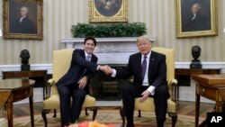 도널드 트럼프 미국 대통령(오른쪽)과 쥐스탱 트뤼도 캐나다 총리가 13일 백악관에서 만나 악수하고 있다.