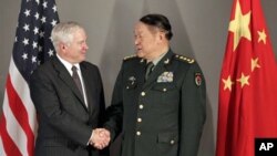Defense Secretary Robert Gates, left, and China's Minister of Defense Liang Guanglie shake hands before a meeting in Hanoi, Vietnam, 11 Oct. 2010