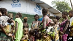 Refugees, who fled the post-election instability in Ivory Coast, wait to be registered at a camp in Liberia