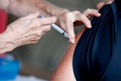 A man receives a COVID-19 vaccine at a clinic at Mother's Brewing Company in Springfield, Mo., on Tuesday, June 22, 2021.(Nathan Papes/The Springfield News-Leader via AP)