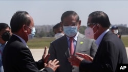 Cambodian Prime Minister Hun Sen, right, talks with his Deputy PMs, Sar Kheng, center, also Minister of Interior Ministry, and Tea Banh, left, also Defense Minister, during the arrival at Phnom Penh International Airport from Myanmar, in Phnom Penh, Cambodia, Jan. 8, 2022. 