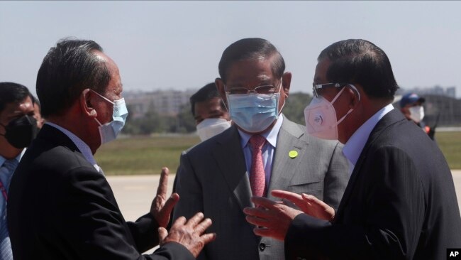 Cambodian Prime Minister Hun Sen, right, talks with his Deputy PMs, Sar Kheng, center, also Minister of Interior Ministry, and Tea Banh, left, also Defense Minister, during the arrival at Phnom Penh International Airport from Myanmar, in Phnom Penh, Cambodia, Jan. 8, 2022.