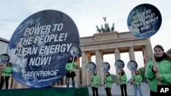 FILE: Greenpeace activists protest in front of the Brandenburg Gate in Berlin, Germany, April 13, 2014.