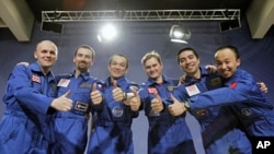 Participants of the Mars500 experiment, which simulated a 520-day flight to Mars, pose for a picture during a news conference in Moscow, November 8, 2011