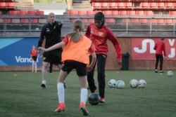 Kamila Nuh (kanan), mengenakan hijab olah raga, saat berlatih sepak bola di Stadion MUP, Vantaa, Finlandia, 1 Juni 2021. (AFP)