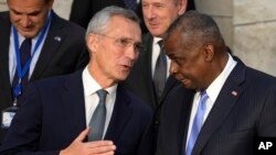 NATO Secretary General Jens Stoltenberg, left, speaks with U.S. Defense Secretary Lloyd Austin during a group photo of NATO defense ministers at NATO headquarters in Brussels, Oct. 21, 2021.