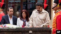 President Nicolas Maduro, right, with Adan Chavez, (left) brother of the late president Hugo Chavez, and Venezuela first lady Cilia Flores, visit the late leader's tomb in Caracas, Venezuela, Nov. 5, 2013. 