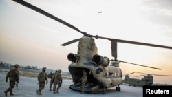FILE - U.S. soldiers from the 3rd Cavalry Regiment load into a CH-47 Chinook helicopter for an advising mission to an Afghan National Army base at forward operating base Fenty in the Nangarhar province of Afghanistan, Dec. 21, 2014. 