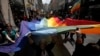 Arhiva - Učesnici Parade ponosa u Beogradu nose veliku zastavu duginih boja, simbol gej pokreta, 27. juna 2013. godine.