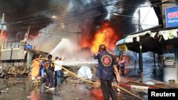 Nhân viên cứu hộ dập tắt đám cháy tại hiện trường vụ nổ bom ở Yala, miền nam Thái Lan.