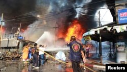 Petugas berusaha memadamkan kebakaran setelah serangan bom di provinsi Yala, Thailand selatan (6/4). 