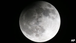 File--The moon seen from the Belarusian capital Minsk, during a partial lunar eclipse, lat April 25, 2013. Scientists believe the Moon and Earth share the same source of water.