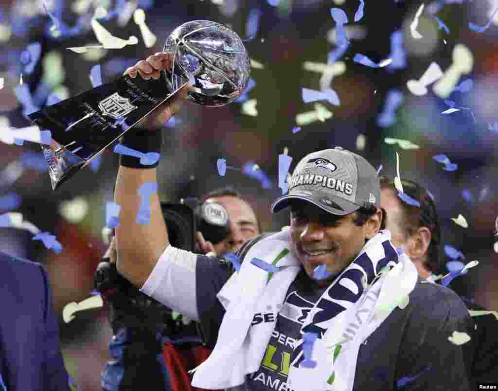 O quarterback dos Seattle Seahawks, Russell Wilson, levanta o troféu Vince Lombardi Trophy depois dos&nbsp; Seahawks derrotarem os Denver Broncos na final da NFL Super Bowl XLVIII, Fev. 2, 2014, Nova Jérsia