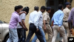 Police officials escort an accused, head covered with black cloth, in the gang rape of a young photojournalist in the Indian financial hub of Mumbai, Aug. 24, 2013.