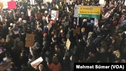 Des centaines de manifestants sont réunis à l'aéroport JFK, à New York, le 28 janvier 2017. (VOA/Mehmet Sümer)