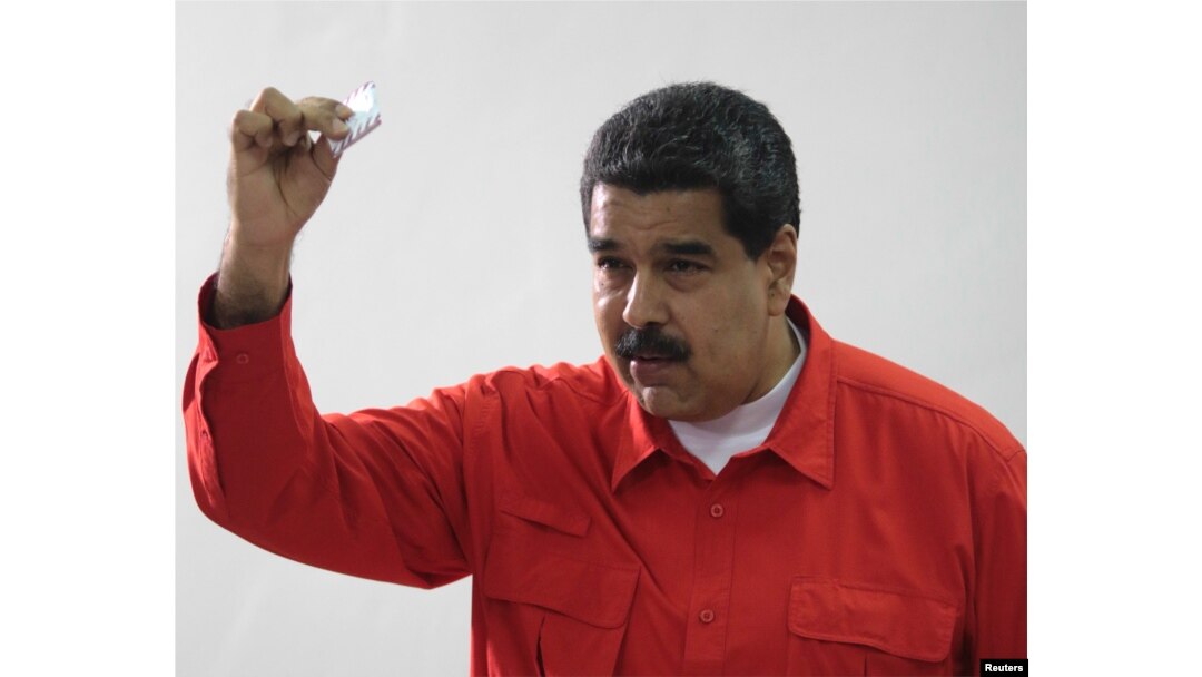 Venezuelan President Nicolas Maduro show his ballot as casts his vote at a polling station during the Constituent Assembly election in Caracas, Venezuela, July 30, 2017.