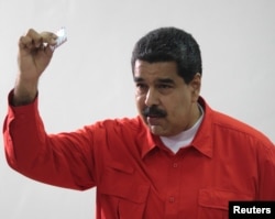 Venezuelan President Nicolas Maduro show his ballot as casts his vote at a polling station during the Constituent Assembly election in Caracas, Venezuela, July 30, 2017.