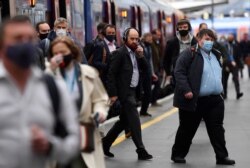 Para pelaju di stasiun kereta Waterloo saat jam sibuk pagi hari di tengah pelonggaran pembatasan pandemi COVID-19, di London, Inggris, Rabu, 19 Mei 2021. (Foto: Toby Melville/Reuters)
