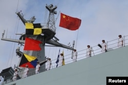 Soldiers of China's People's Liberation Army (PLA) stand on a ship sailing off from a military port in Zhanjiang, Guangdong province, July 11, 2017.