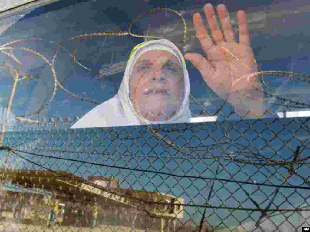 A Palestinian woman waves her hand as she sits in a bus before leaving Rafah border crossing for the annual haj pilgrimage in Mecca, in the southern Gaza Strip October 14, 2011.