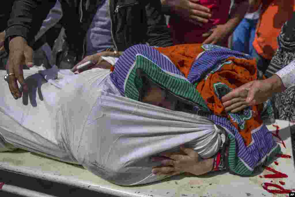 A Kashmiri woman hugs the body of a relative as it is carried outside a local hospital in Srinagar, Indian controlled Kashmir. Police say suspected rebels shot and killed two activists linked to a pro-India Kashmiri group.